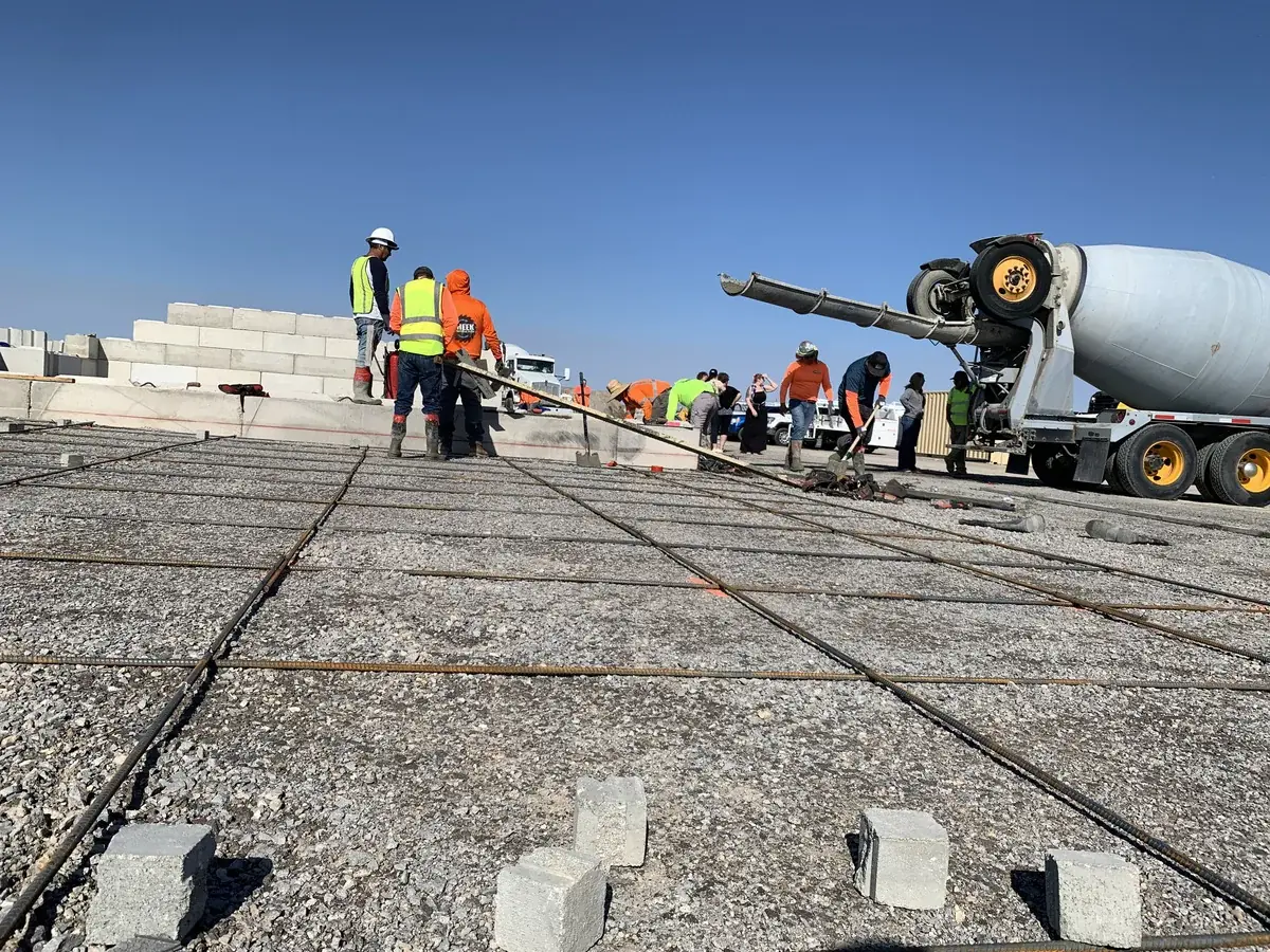 Construction workers pouring concrete on site